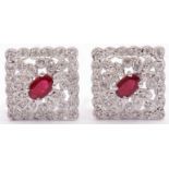 Pair of diamond and ruby cluster earrings, an off-square design centring an oval faceted ruby within