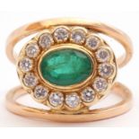Emerald and diamond cluster ring, a stylised design, the centre with an oval faceted emerald, 8mm