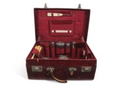 Edwardian red morocco leather travelling case with some original fittings including four silver