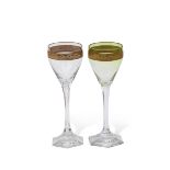 Pair of wine glasses, probably Moser, with green tint and a gilt engraved band above a faceted