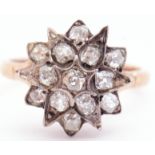 Antique diamond star cluster ring featuring 13 old mine cut diamonds in claw and grain settings,