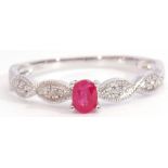 Modern ruby and diamond set ring centring an oval faceted ruby, raised between small diamond set