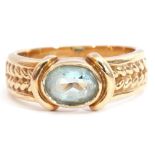 9ct gold and blue stone ring, the oval faceted stone bezel set and raised between rope twist