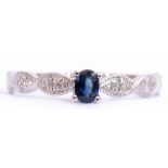 Modern sapphire and diamond ring centring an oval faceted sapphire, raised above diamond set plaited
