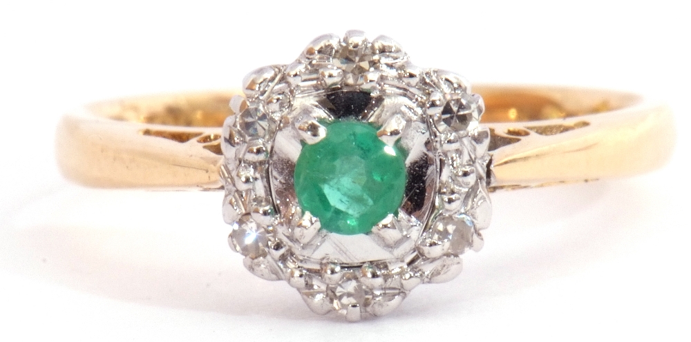 Modern 18ct gold emerald and diamond cluster ring, the round cut emerald four claw set and raised