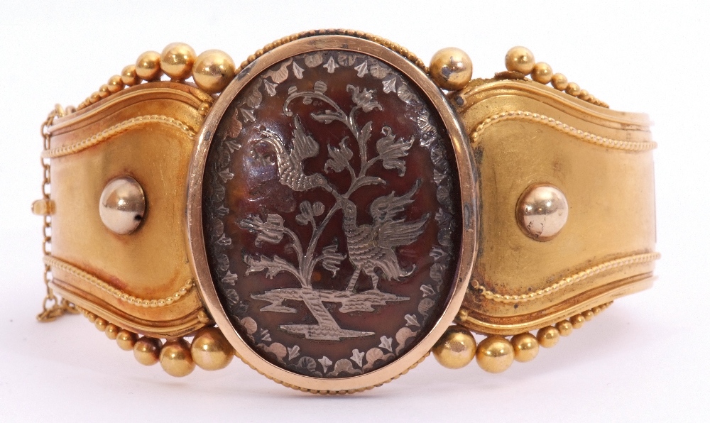 Victorian Etruscan hinged bangle, the top section centring a large oval pique panel inlaid with a