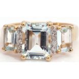 9ct gold pale blue stone and diamond ring, a design with three graduated emerald cut pale blue