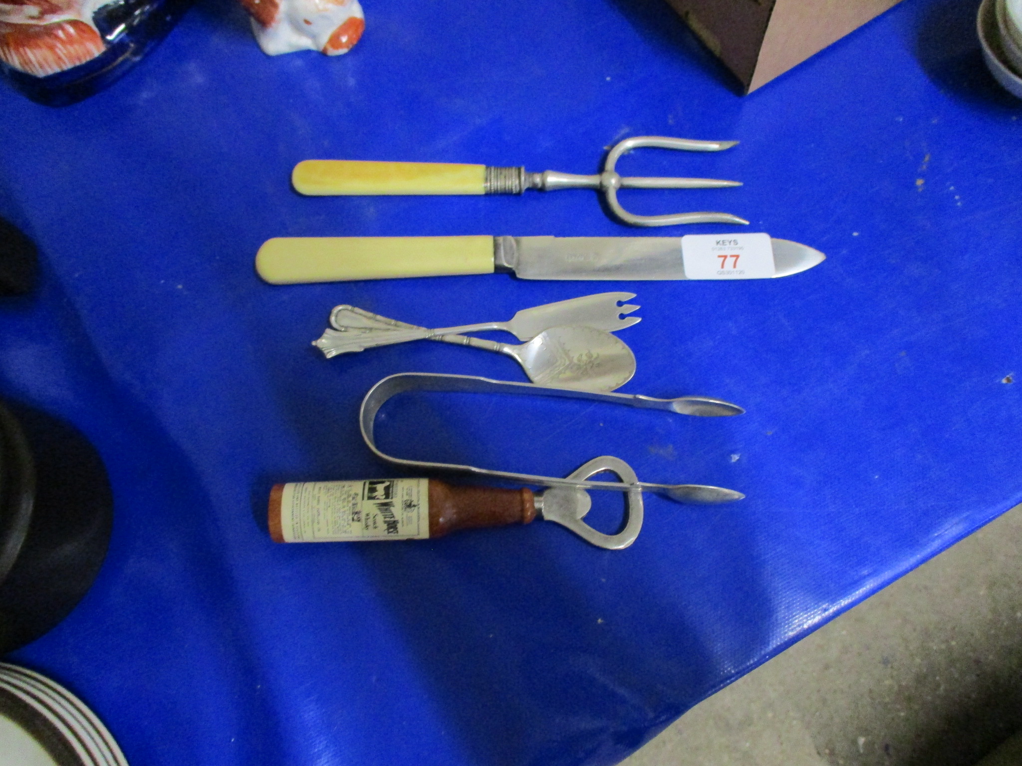 BOTTLE OPENER AND PLATED KNIFE AND FORK AND TEA SPOON AND SUGAR TONGS