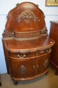 European oak chiffonier, the arched back and bow front moulded throughout with panels of baskets