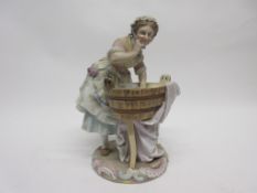 Late 19th century Continental porcelain model of a washer girl on a circular base with tub of