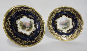 Pair of late 19th century Coalport plates, the blue ground with central cartouche with a landscape