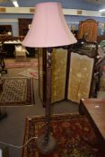 Carved oak standard lamp, the stem decorated with leaves and foliage etc, together with a pink