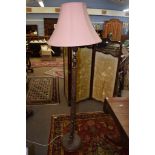 Carved oak standard lamp, the stem decorated with leaves and foliage etc, together with a pink