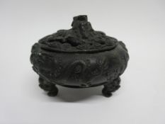 Chinese bronze pot and cover on three feet, modelled in relief with dragons, the cover with