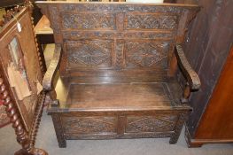 Oak settle, carved back, arms and front frieze, lift up seat with box below on plain stile feet,