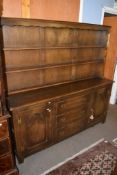 Reproduction Reprodux oak dresser, plate rack back over base fitted with three central drawers