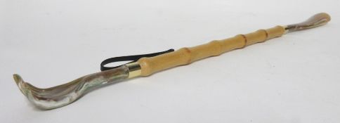 Wooden shoe horn with back stretcher at one end in plastic holder