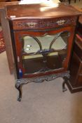 Late 19th century mahogany display cabinet of serpentined form, single drawer over glazed door