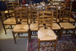 Set of ten matched Lancashire style ladder back rush seat dining chairs comprises two carvers and