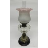 Oil lamp with brass column and glass reservoir with pink shade
