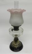 Oil lamp with brass column and glass reservoir with pink shade