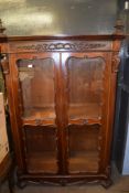 Mahogany display cabinet, decorated throughout with C-scroll and other carved detail, the top