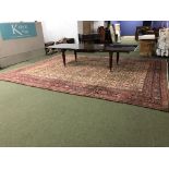 Large old wool Middle Eastern carpet with floral pattern on an oatmeal ground surrounded by a