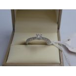 Platinum & diamond ring with central 4 claw set solitaire diamond with single cut diamond shoulders,
