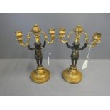 Pair of Rococo candlesticks with gilded base surmounted by bronzed cherubs