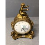 A C19th Ormolu clock with cherub finial and white face and black numbers to dial