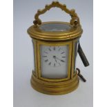Miniature French C19th oval carriage timepiece, the lever movement with white enamel dial & roman