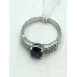 14ct White gold sapphire & diamond ring with central oval free cut sapphire with double line of