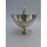 George III oval pedestal swing handled sugar basket with engraved cartouches & swag border on a