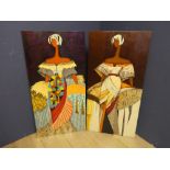 A pair of large heavy decorative panels depicting ladies in colourful and tribal costumes with