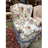 Large winged armchair upholstered in floral fabric