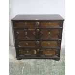 An oak chest of 2 short over 3 long drawers, with carved and applied moulding, and small bun feet