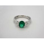 18ct White gold ring with central emerald flanked by trillion cut diamonds size L