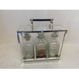 Contemporary chromium three decanter tantalus CONDITION: minor chips to bottle stoppers