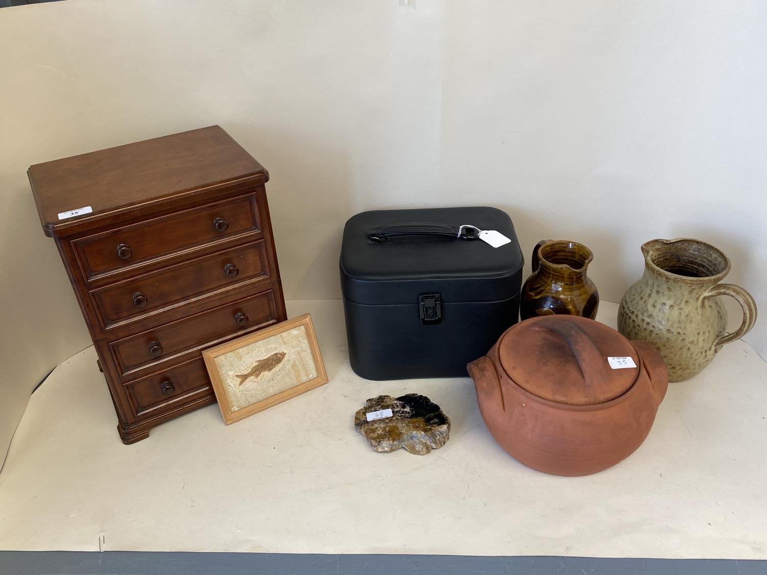 Polished mahogany apprentices piece as a chest of 4 long drawers, two pottery jugs and casserole,