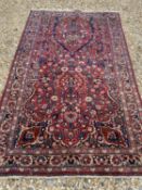 A Shirvan red ground rug having a central medallion within a surround of animal and foliate stylised