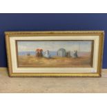 Gilt framed oil painting of a Victorian beach scene with figures and beach hut 18x47.5cm