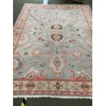 A pretty contemporary rug, in colours of light greens and pastels, in generally good condition