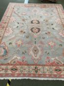 A pretty contemporary rug, in colours of light greens and pastels, in generally good condition