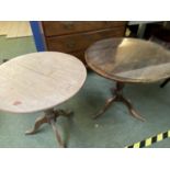 2 circular pedestal tables, both with wear, dark one uneven, light one with crack on top