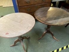2 circular pedestal tables, both with wear, dark one uneven, light one with crack on top