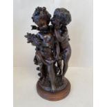 Bronze figure group of 2 harvest cherubs on a circular wooden stand. 43cm H CONDITION: No visible