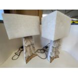 Pair of heavily carved wooden table lamps with rectangular canvas shades CONDITION: some wear -