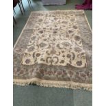 A cream ground rug with all over fawn & blue stylised patterns & borders