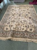 A cream ground rug with all over fawn & blue stylised patterns & borders