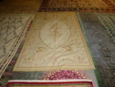 Small Aubusson rug, soft oatmeal ground with soft colours of an oval of leaves, floral panels and